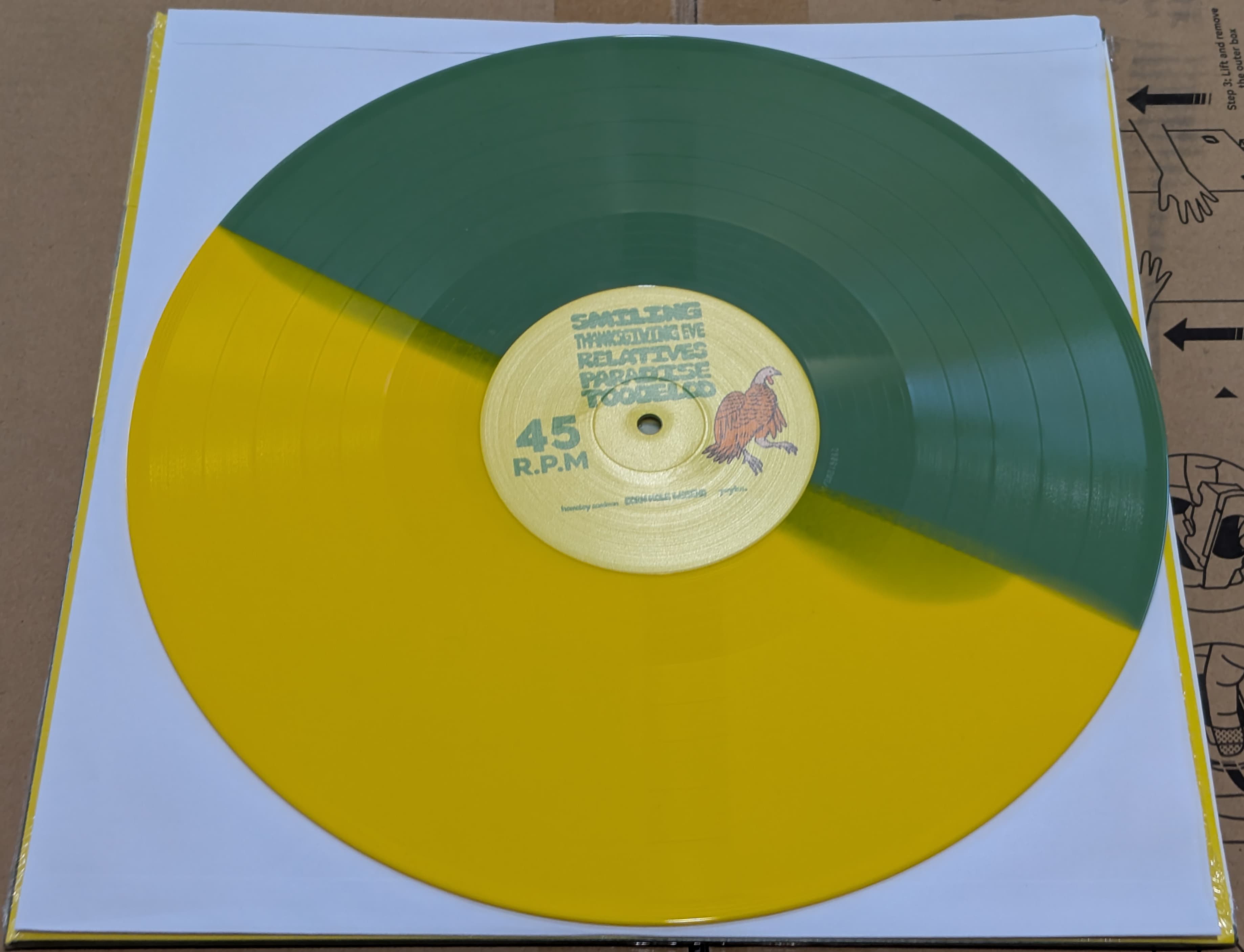 A vinyl record with a split green and yellow color design.