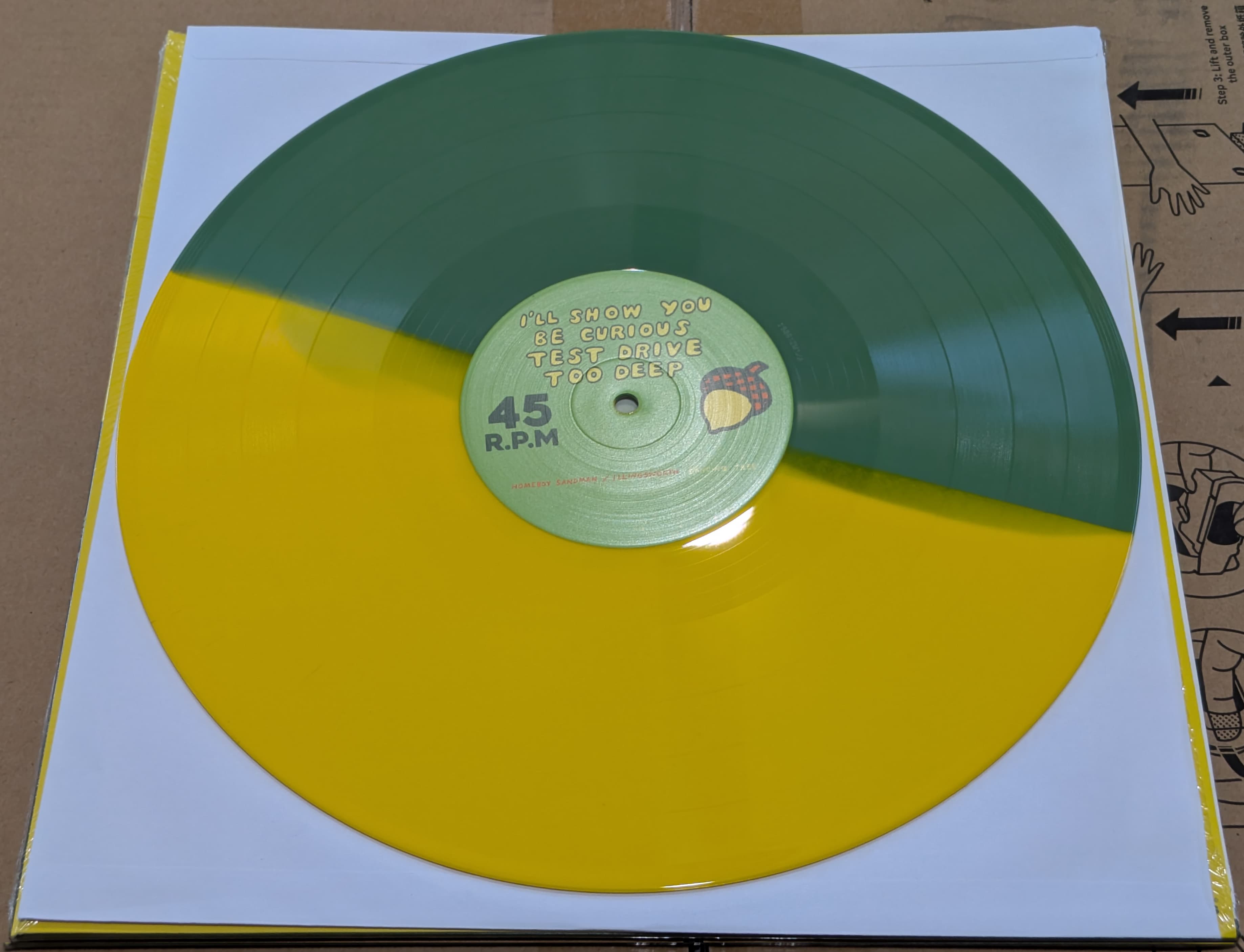 A vinyl record with a split green and yellow color design.